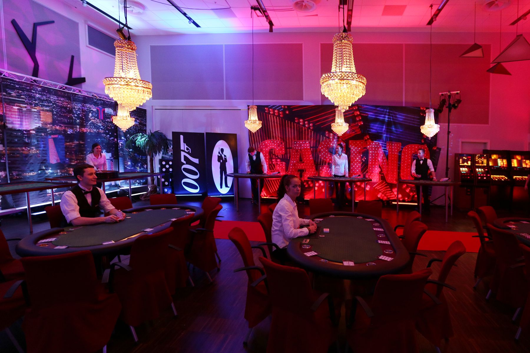 Casinosal med lysekroner, 007-skilte og pokerborde klar til gæster