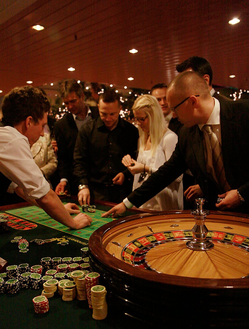 Croupier deler kort ved blackjack-bordet under et firmaevent