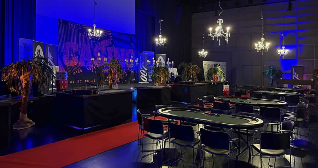 Festsal indrettet med scene og flere pokerborde til udlejning
