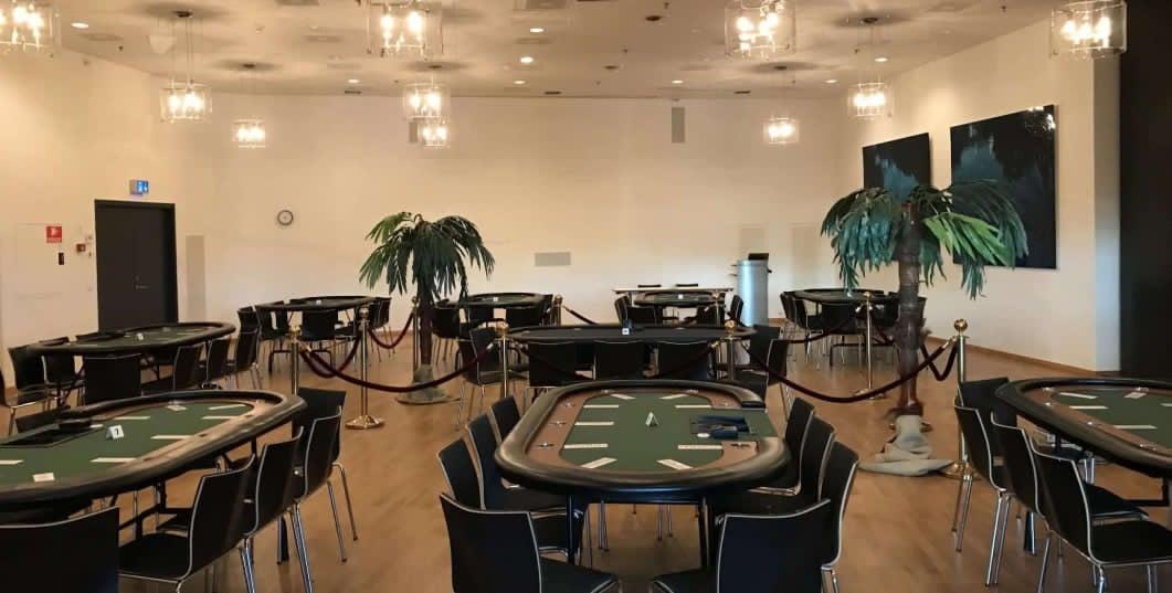 Pokerturnering opsat med borde, palmer og afspærring